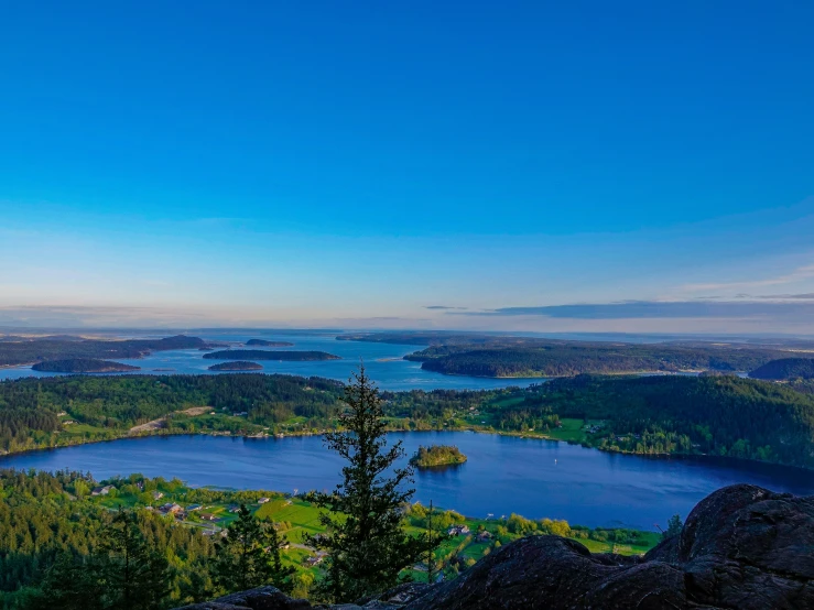 two people standing on a hill overlooking some water