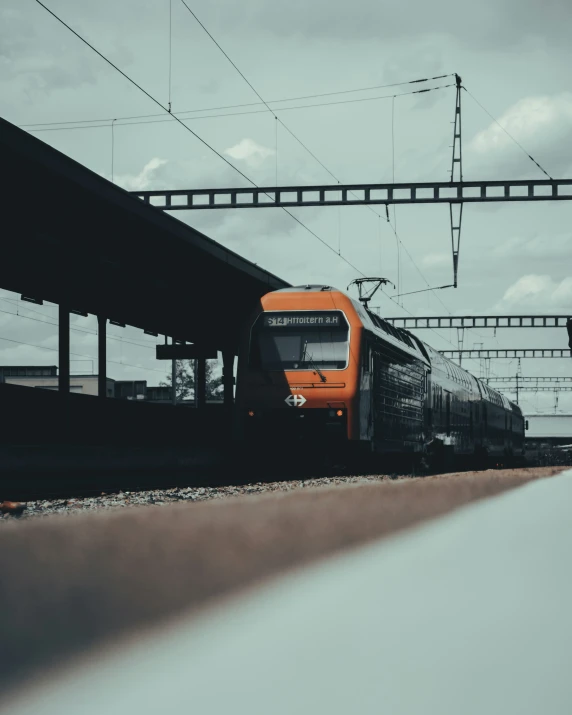 a train traveling down tracks next to a station