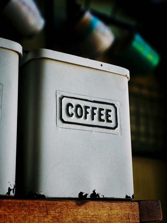 two coffee cans sitting on top of a wooden table