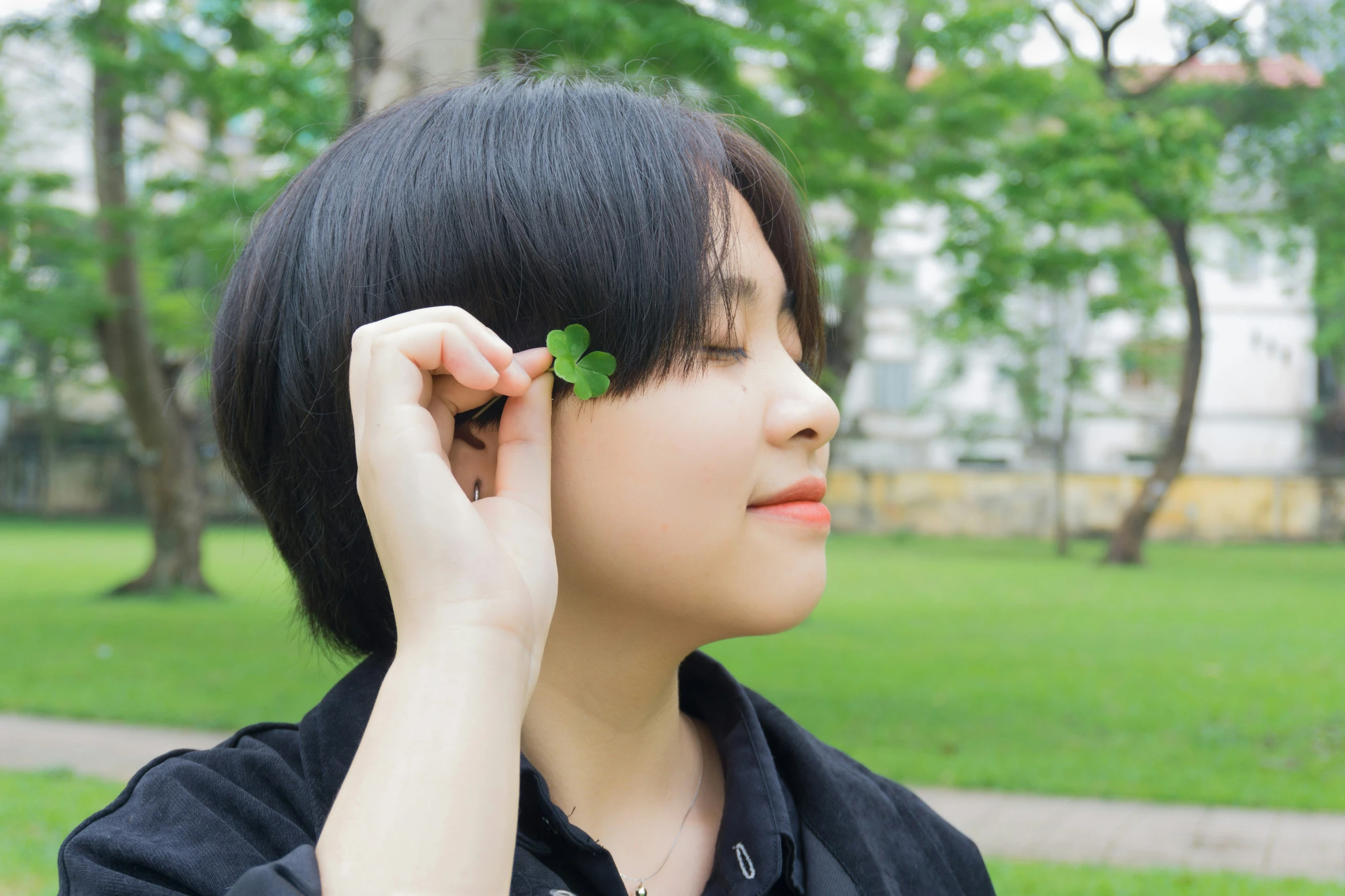 a woman holding a leaf of some sort near her ear