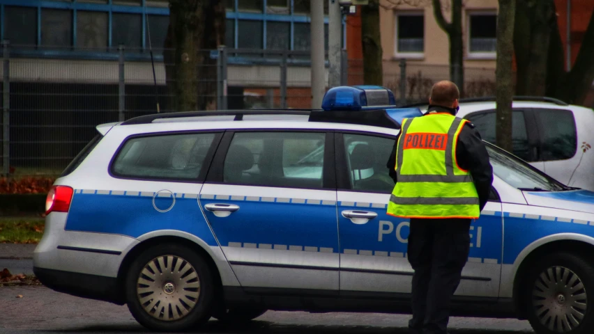 a man is standing next to a police car