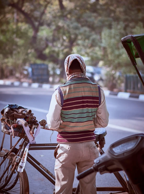 a man in a vest, next to a bicycle