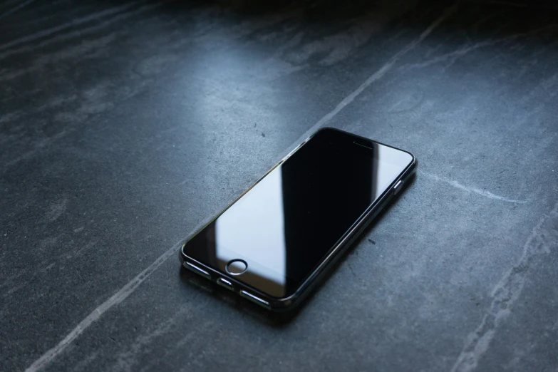 a smartphone is laying on a table next to a phone charger