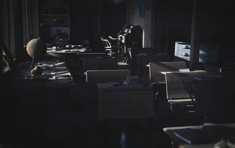 a dark room with chairs and desks on it