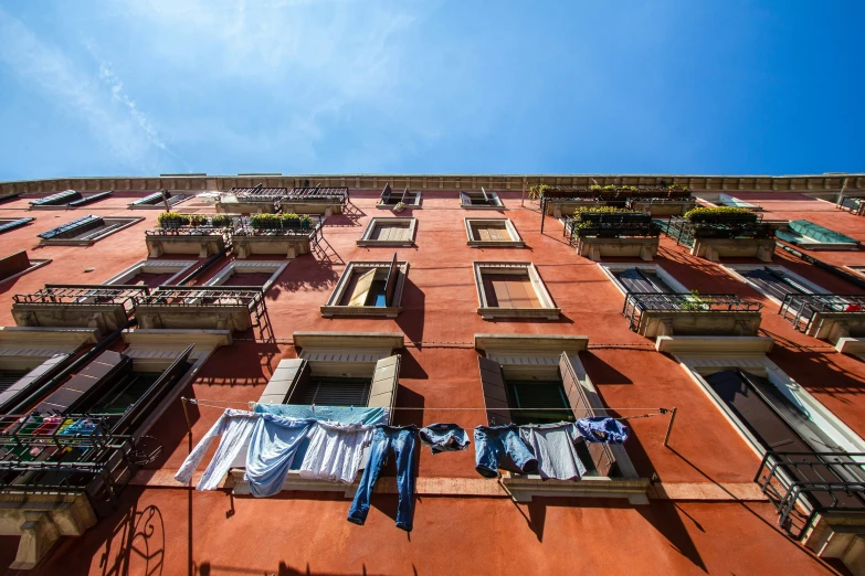 clothes hung out to dry in the windows of an apartment building