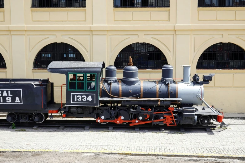 an antique train sitting on display in front of a building