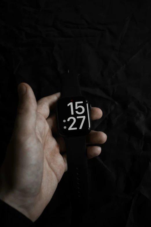 a person holds a black wrist watch