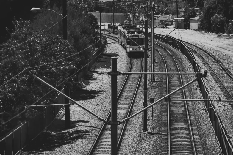 a black and white po of train tracks next to an open area