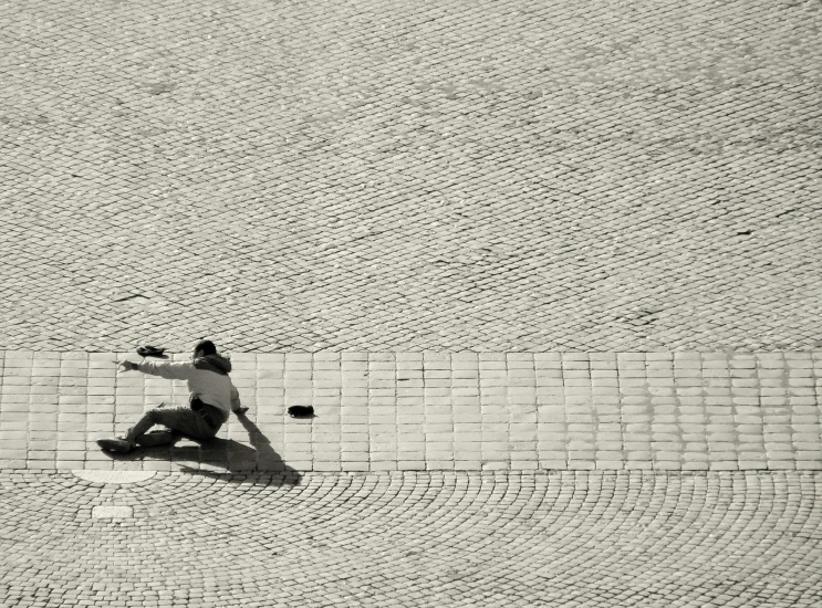 a man riding a skateboard down a brick sidewalk