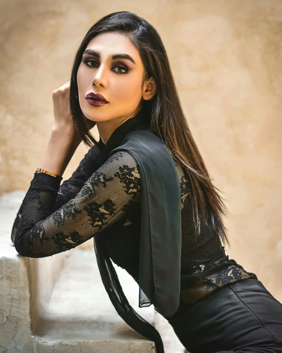 a woman with long hair and dark eyes is posing on stairs