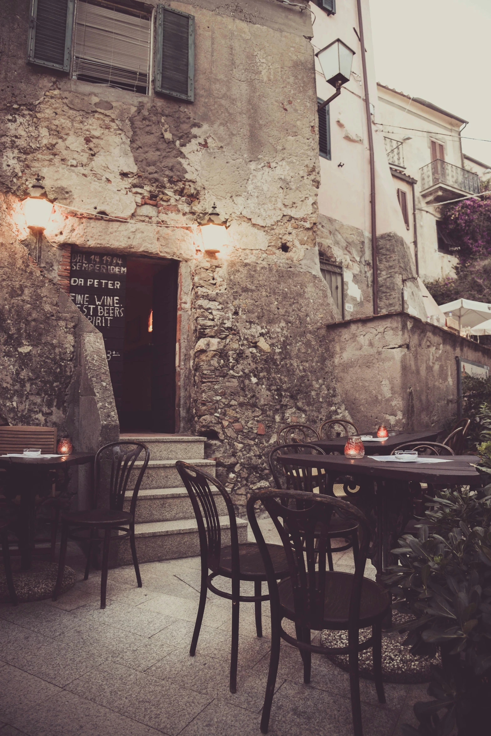 tables outside an old building with a lot of lights