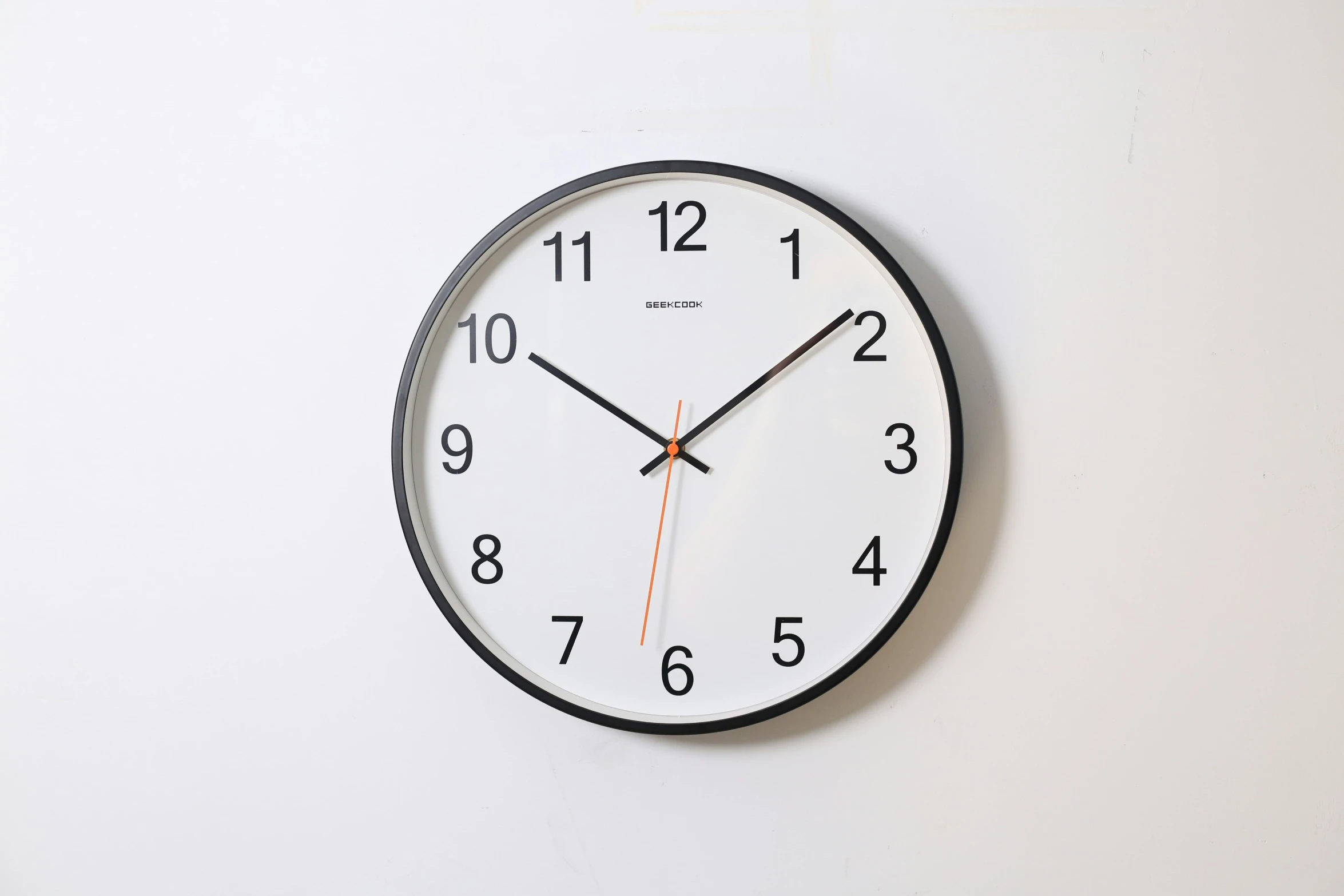 a clock shows six o'clock to twelve on a white wall