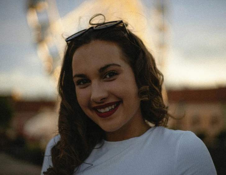 a young woman wearing sunglasses posing for the camera