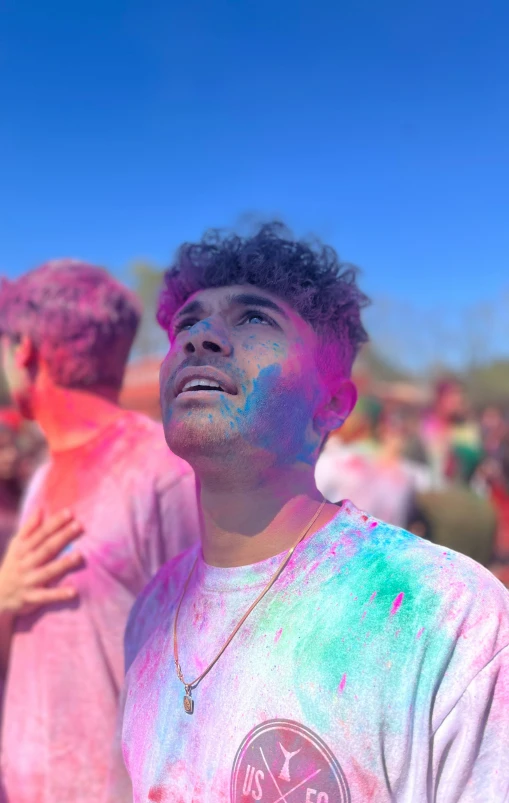 a young man smiles and watches the color run