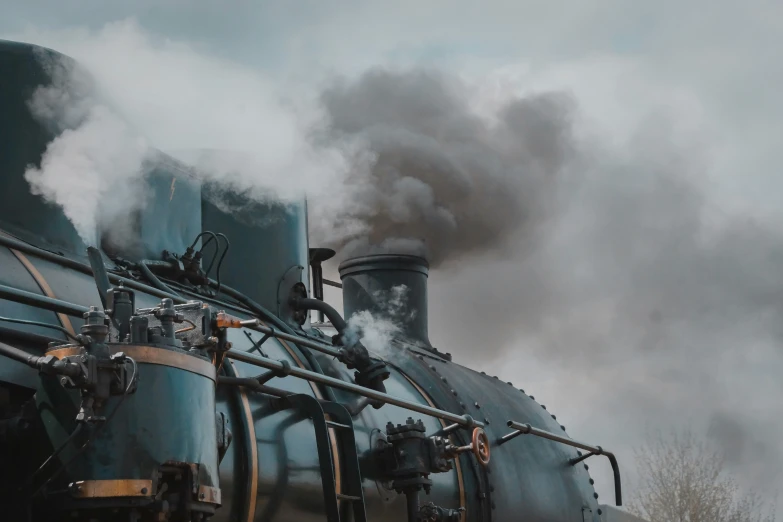 a train with steam pouring out of it's stacks