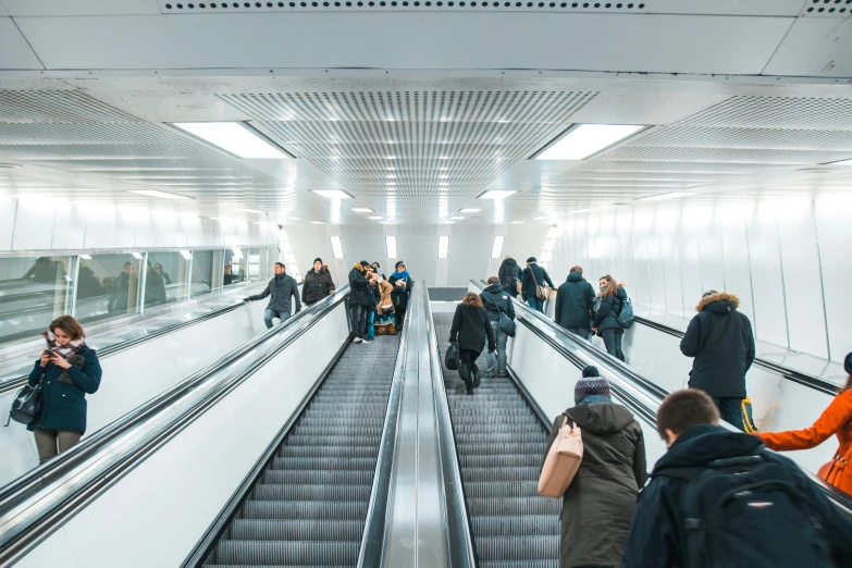 some people are walking up a set of escalators