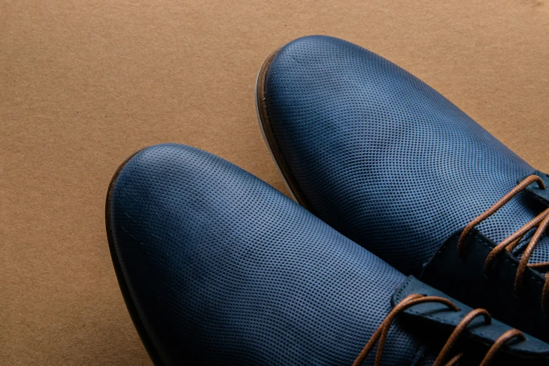 the back view of shoes that are blue with brown laces