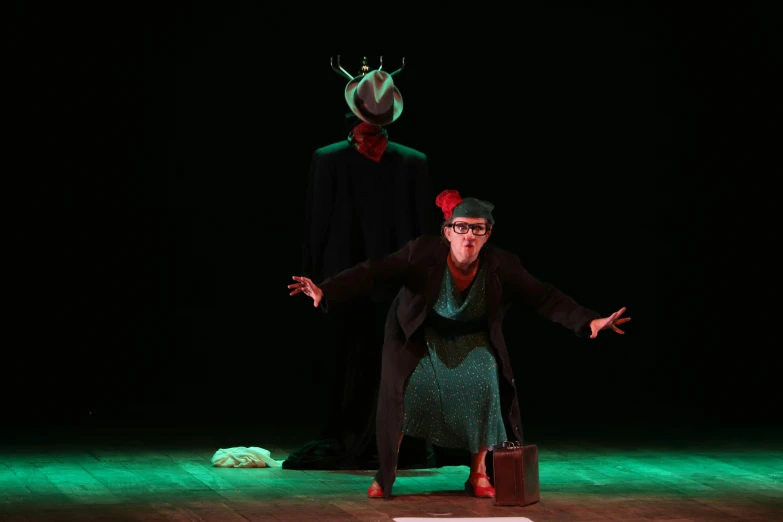 a man in a hat standing next to a woman on a stage