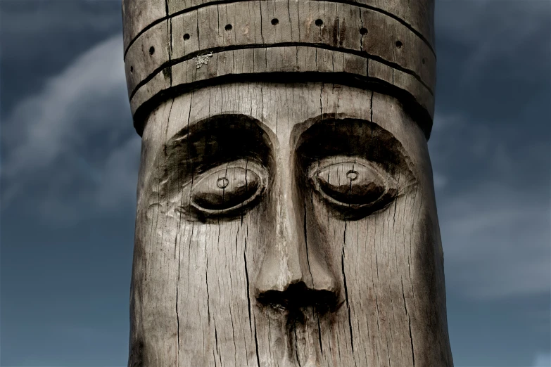 a close up of a statue with clouds in the background