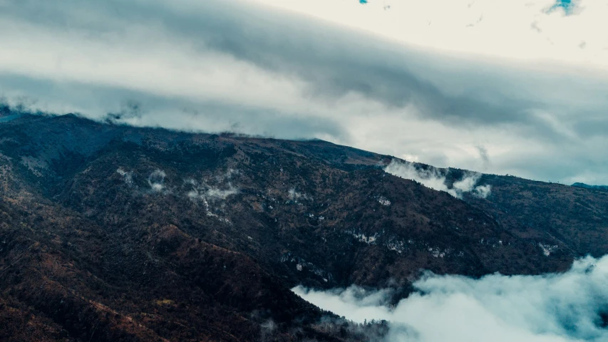 a mountain with fog and mist rising from the top