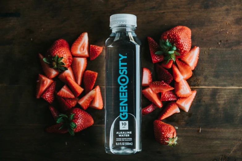 a bottle of water sits on a table surrounded by fruit