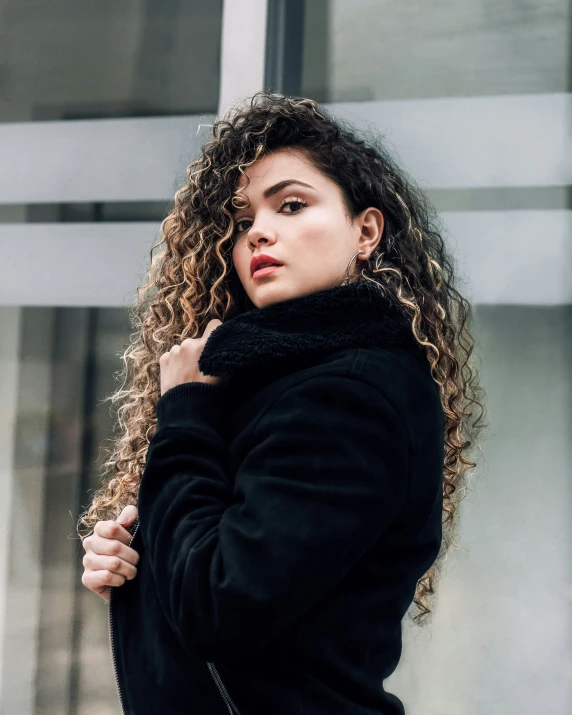 a young lady is standing near a building