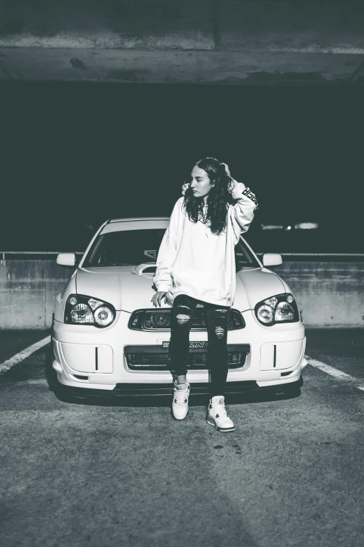 a woman is sitting next to her car with a cell phone in her hand