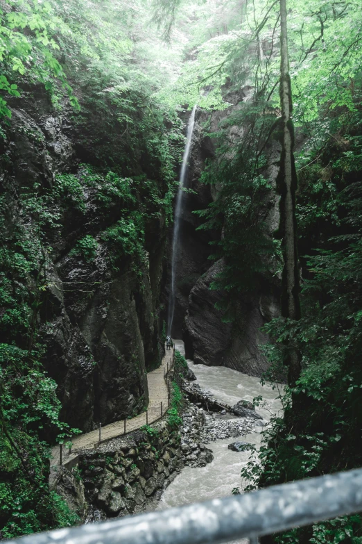 the view from above a waterfall at a bridge