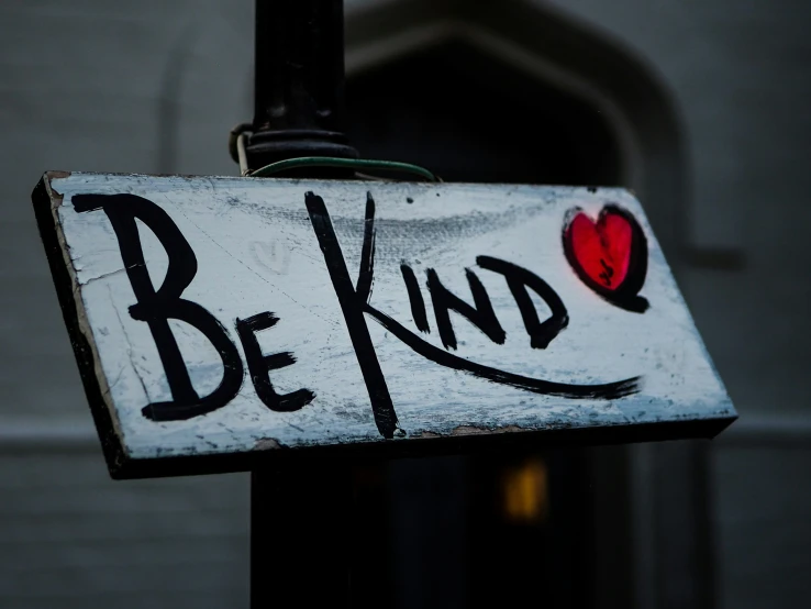 this is an old sign that says be kind on it