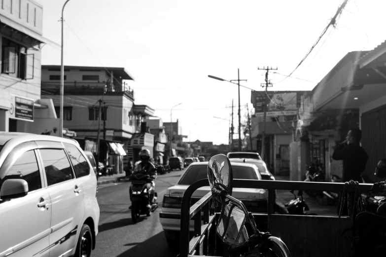 black and white po of motorcycles and cars on street