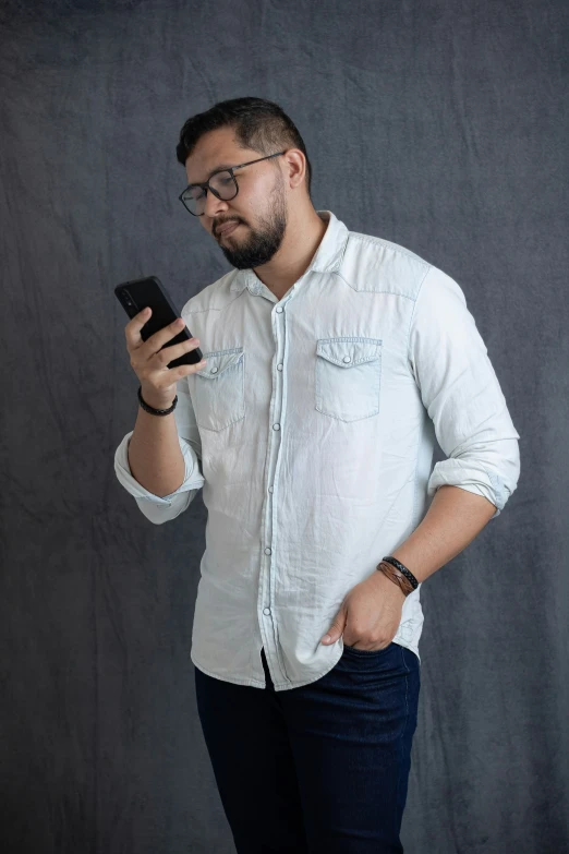 a man in glasses looking at his cell phone