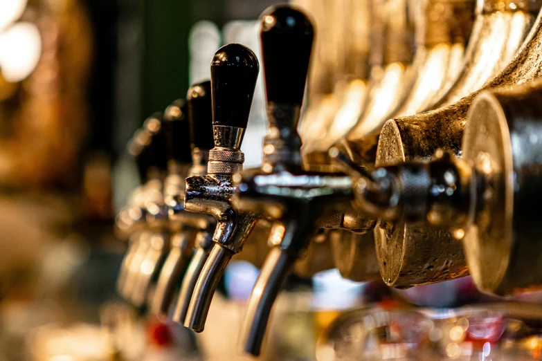 a row of beer taps in a glass case