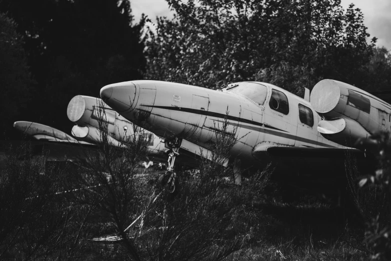 black and white pograph of two airplanes sitting in grass