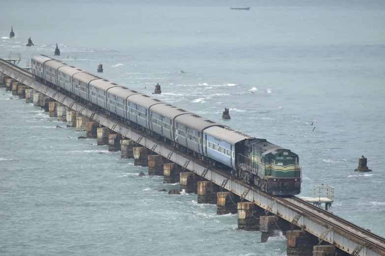 a train rides over a rail bridge in the ocean