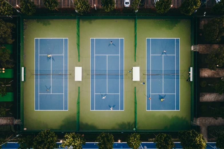 aerial view of four tennis courts in an urban setting