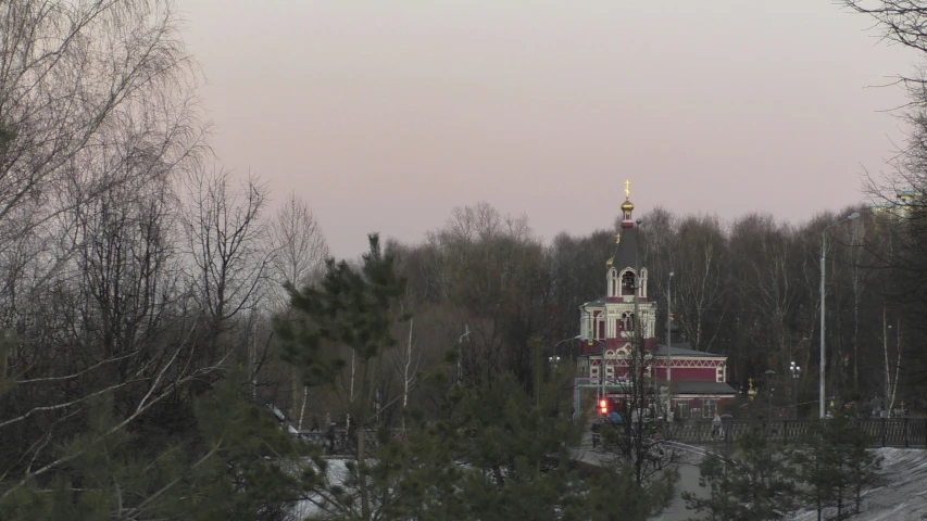 a big white and red church in a wooded area