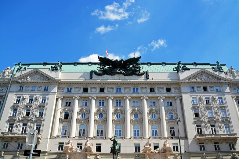 a building has statues around it and a sky background