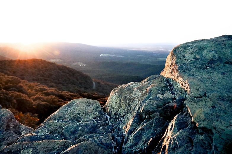 the sun is setting on top of a mountain