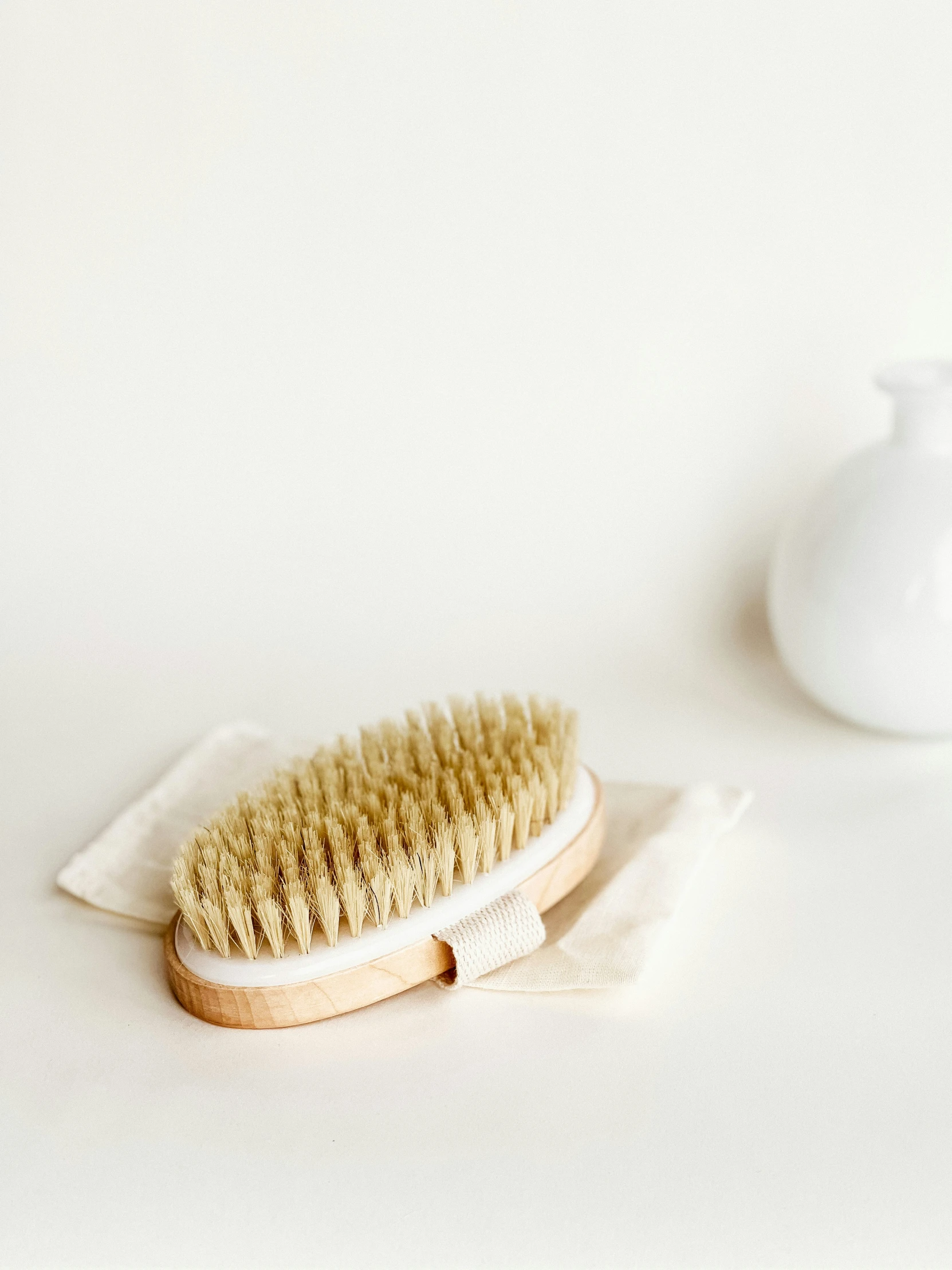 a hair brush on a cloth near a white bowl