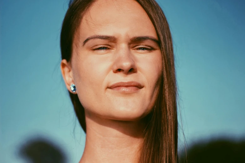 a woman with large earrings staring straight ahead