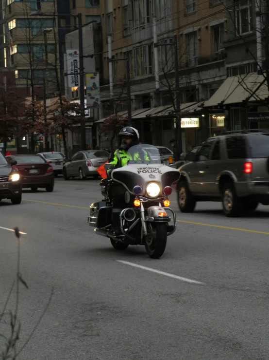 a motorcyclist is traveling down the road in a downtown area