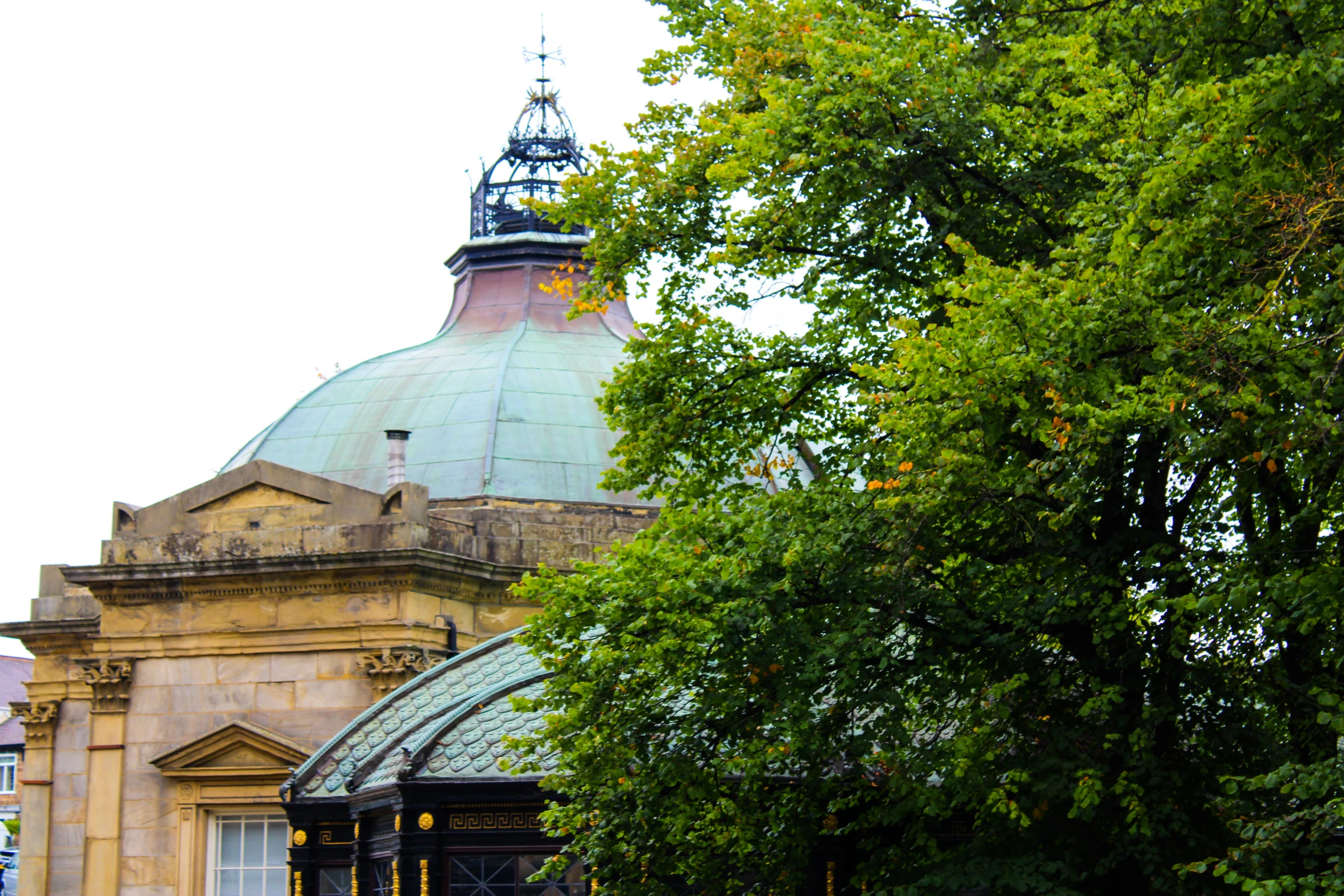 a building with green domes on top and trees surrounding