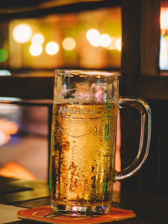 beer in a glass mug sitting on a coaster