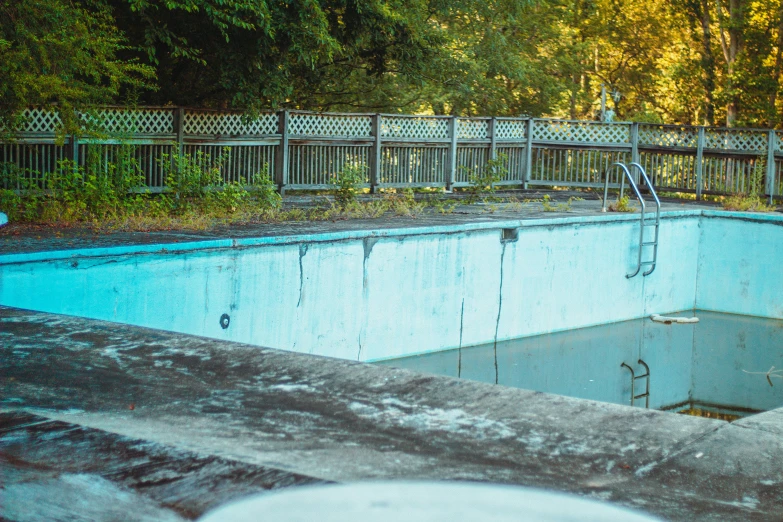 a pool in the middle of a park with trees in the background