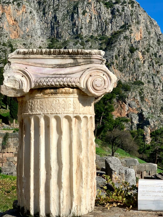 a very old looking old stone column with a stone wall