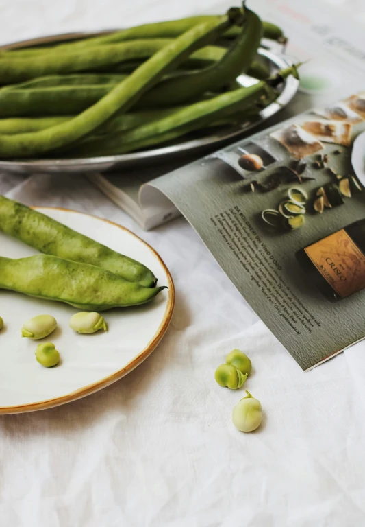 green beans and greens on a table next to a plate with some food