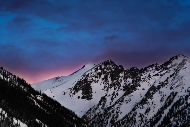 a picture of a snow covered mountain with mountains in the background