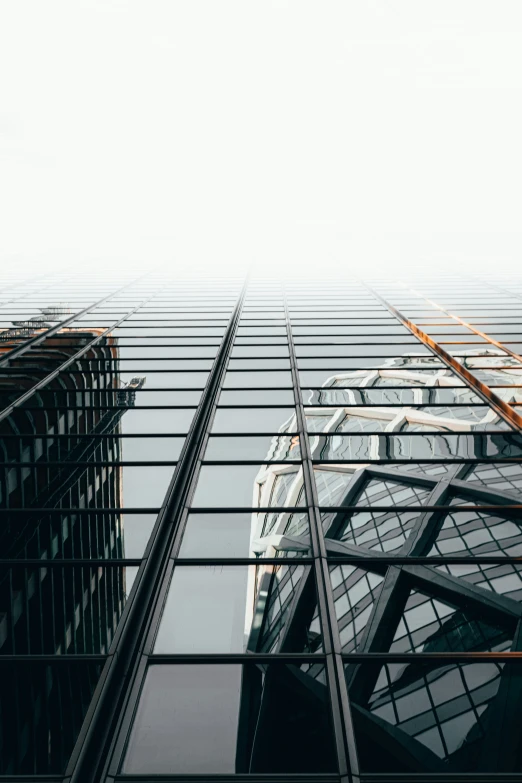 buildings reflect in the glass windows of a building