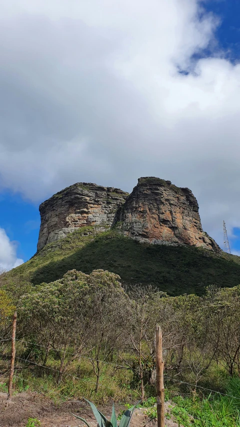 a large rock formation in the distance on top of a hillside