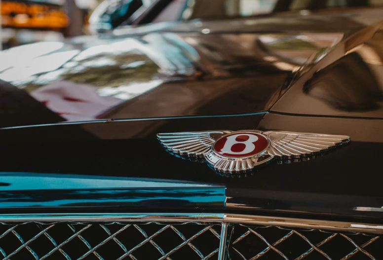 the bentley emblem on a blue car at a car show